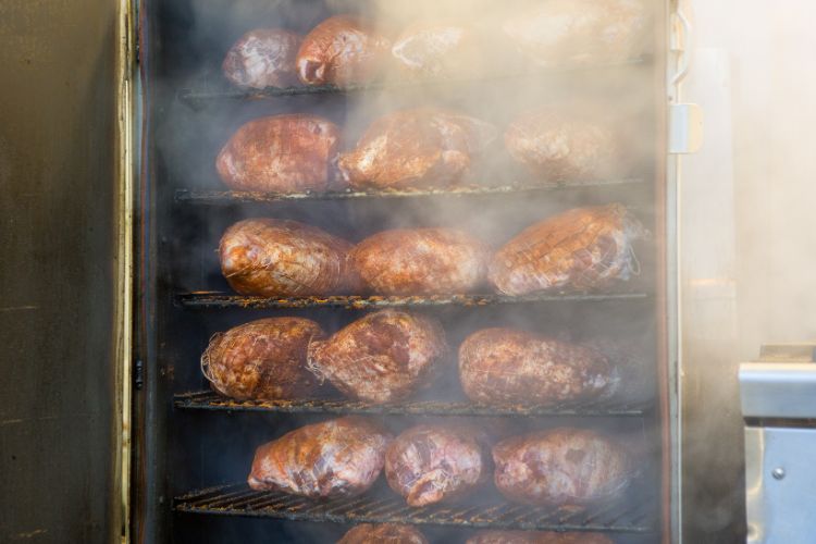 Meat being smoked inside a barbecue smoker